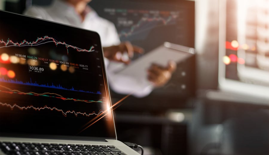 Laptop and data stock market on screen. Businessman using tablet and analyzing stock exchange online in monitoring room background, forex trading graph, stock market and financial investment concept. All on laptop screen are design up.